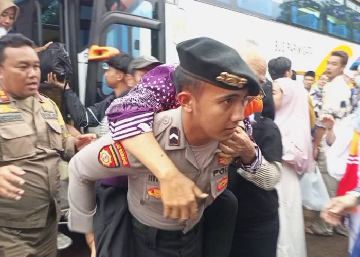 Tak Bisa Berdiri, Seorang Polisi di Kuningan Sigap Gendong Jemaah Haji